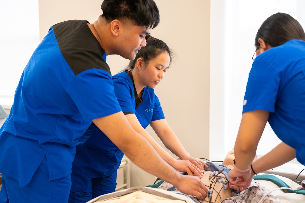 Group of nursing students conducting a medical procedure in a training room.