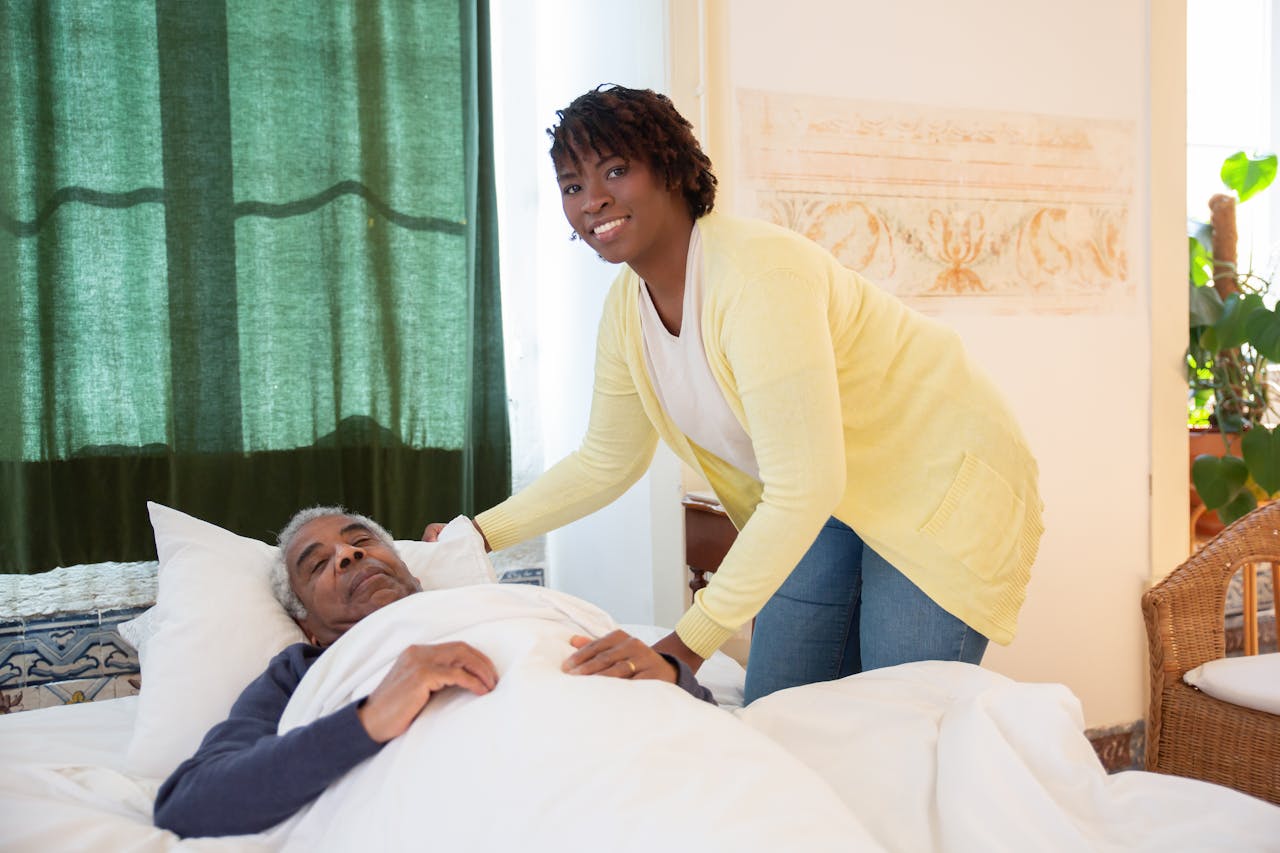 A woman tending to an elderly man in a bright and warm bedroom, symbolizing care and family support.